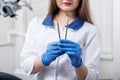 Portrait of young beautiful female dentist holding dental tools at the modern dental office Royalty Free Stock Photo