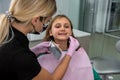 Female dentist checking and choosing teeth color with palette for girl Royalty Free Stock Photo