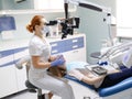 Female dentist with dental tools - microscope, mirror and probe treating patient. Medicine, dentistry and health care Royalty Free Stock Photo