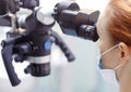 Female dentist with dental tools - microscope, mirror and probe treating patient. Medicine, dentistry and health care Royalty Free Stock Photo