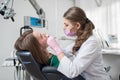 Female dentist with dental tools - mirror and probe checking up patient teeth at dental clinic office Royalty Free Stock Photo