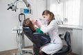 Female dentist with dental tools - mirror and probe checking up patient teeth at dental clinic office Royalty Free Stock Photo