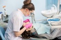 Female dentist with dental tools - mirror and probe treating patient teeth at dental clinic office Royalty Free Stock Photo