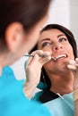 A female dentist examines the oral cavity of the patient with a tool with a mirror. Close-up portrait of a patient with Royalty Free Stock Photo