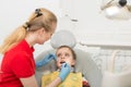 Female dentist examines the teeth of the patient child. Child mouth wide open in the dentist`s chair. Close-up Royalty Free Stock Photo