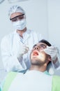 Female dentist examining mans teeth