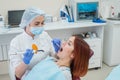 Female dentist fixed and dry dental fillings with light. Beautiful female dentist putting a filling on a tooth with caries of a