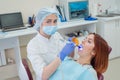 Female dentist fixed and dry dental fillings with light. Beautiful female dentist putting a filling on a tooth with caries of a