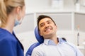 Female dentist with happy male patient at clinic Royalty Free Stock Photo