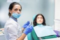 Female dentist holding pliers.