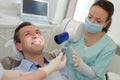 Female dentist with male patient at dental office