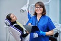 Female dentist, nurse doctor with clipboard phone in dental office Royalty Free Stock Photo