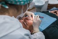 Female dentist with a patient in her office. Patient with open mouth and woman dentist working. dental health concept