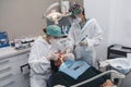 Female dentist with a patient in her office. Patient with open mouth and woman dentist working. dental health concept