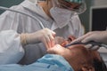 Female dentist with a patient in her office. Patient with open mouth and woman dentist working. dental health concept