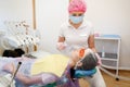 Female dentist puts mask on patient face