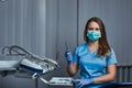 Female dentist holding dental mirror while sitting in her dentist office. Royalty Free Stock Photo