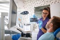 Female dentist showing dental x-ray footage to patient