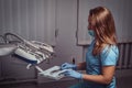 Female dentist sitting on a chair at his workplace in a dental clinic. Royalty Free Stock Photo