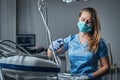 Female dentist sitting on a chair at his workplace in a dental clinic. Royalty Free Stock Photo