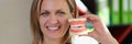 Female dentist smiling and shows artificial jaws in her hand closeup.