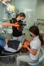 Female dentist with special camera with flash ring shadowless making shots of patients smile