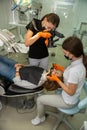 Female dentist with special camera with flash ring shadowless making shots of patients smile