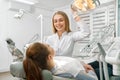 Female dentist talking with patient lying on dental chair Royalty Free Stock Photo