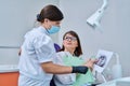 Female dentist talking to woman patient, discussing x-rays of teeth and jaws