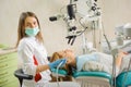 Female dentist treating caries using microscope at the dentist office