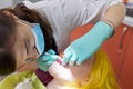 Female dentist treating teeth to patient, young woman in chair at dental clinic Royalty Free Stock Photo