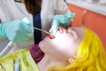 Female dentist treating teeth to patient, young woman in chair at dental clinic Royalty Free Stock Photo