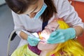 Female dentist treating teeth to patient, young woman in chair at dental clinic Royalty Free Stock Photo