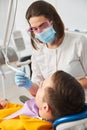 Female dentist using dental scaler on a man