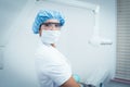 Female dentist wearing surgical mask and safety glasses