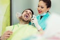 Female dentists examining and working on male patient