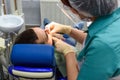 Female dentists working on young male patient. Dentist`s office