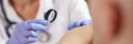 Female dermatologist examining patient skin with magnifying glass at consultation in hospital. Royalty Free Stock Photo