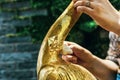 A female designer restores and covers a wooden flamingo statuette with a golden potala