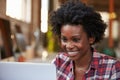 Female Designer Using Laptop At Desk In Modern Office