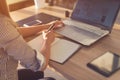 Female designer using laptop, sketching at blank notepad. Woman hand writing in notebook on wooden desk. Royalty Free Stock Photo