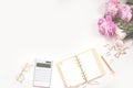 Female diary, golden pen and jewelry, pink peonies, calculator on a white background. Copy space