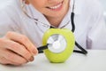 Female dietician examining green apple