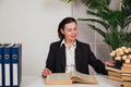 a female director in the office sits at a desk with a book in the office