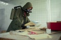 Female disaster survivor in a post apocalyptic setting wearing a gas mask and reading a document. Environmental Royalty Free Stock Photo