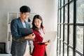 Female discussing new project with male colleague. Mature woman talking with young man in office Royalty Free Stock Photo