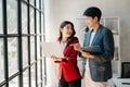 Female discussing new project with male colleague. Mature woman talking with young man in office Royalty Free Stock Photo