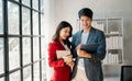 Female discussing new project with male colleague. Mature woman talking with young man in office Royalty Free Stock Photo