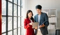 Female discussing new project with male colleague. Mature woman talking with young man in office Royalty Free Stock Photo