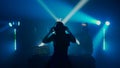 Female DJ Leading the Party at Nightclub with Crowd in Silhouette